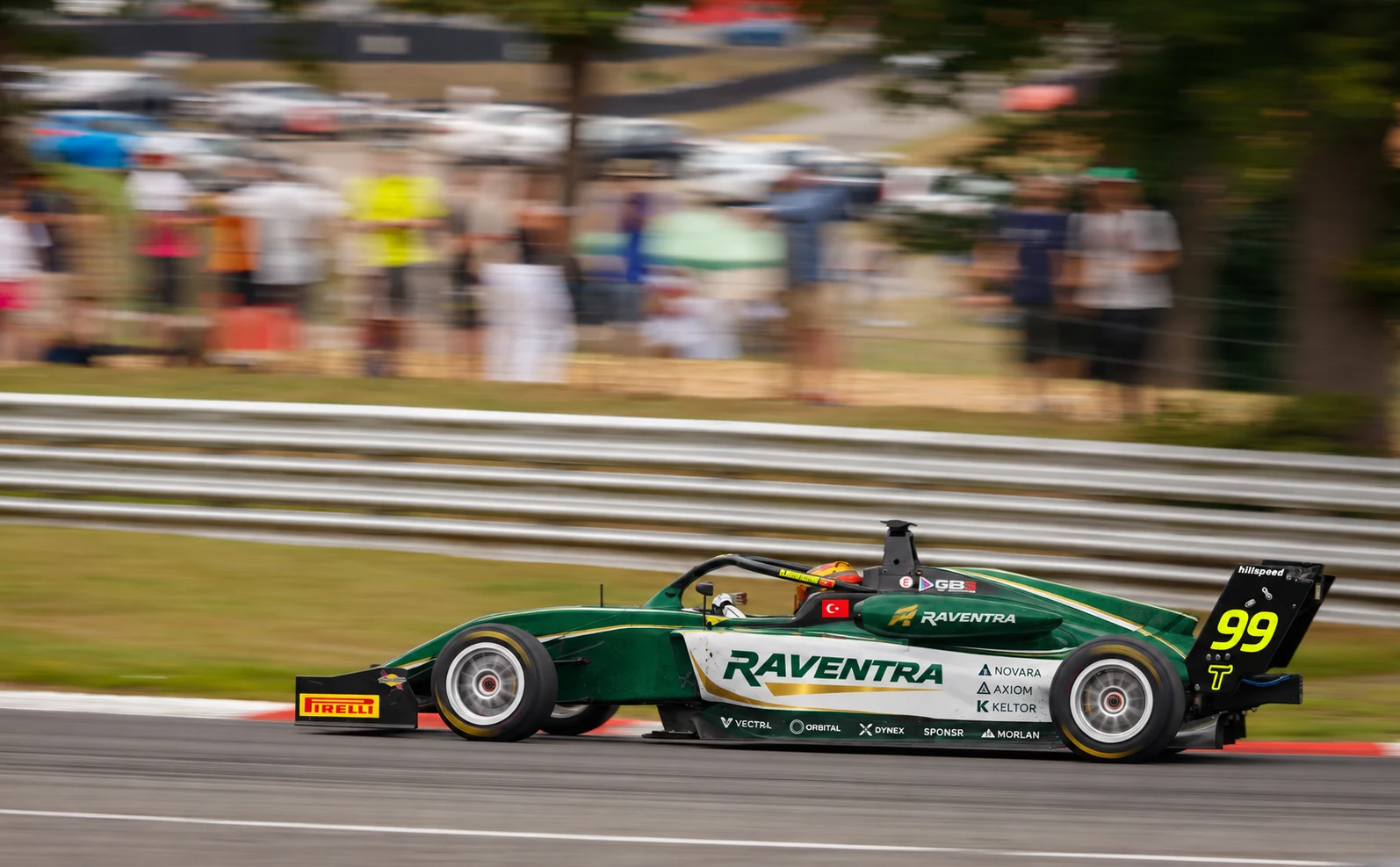 A green GB3 single-seater at speed past a blurred crowd (SPONSR livery concept).